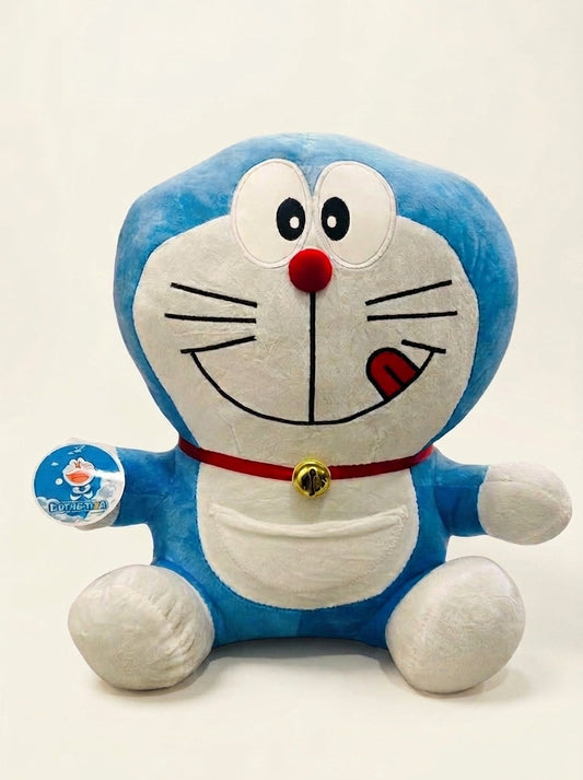 A blue and white plush toy of Doraemon sitting against a plain white background, holding a small blue tag.