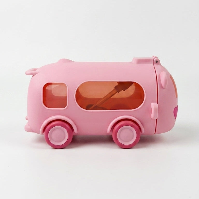 A pink toy bus-shaped container with orange-tinted windows and pink wheels, photographed on a clean white background.