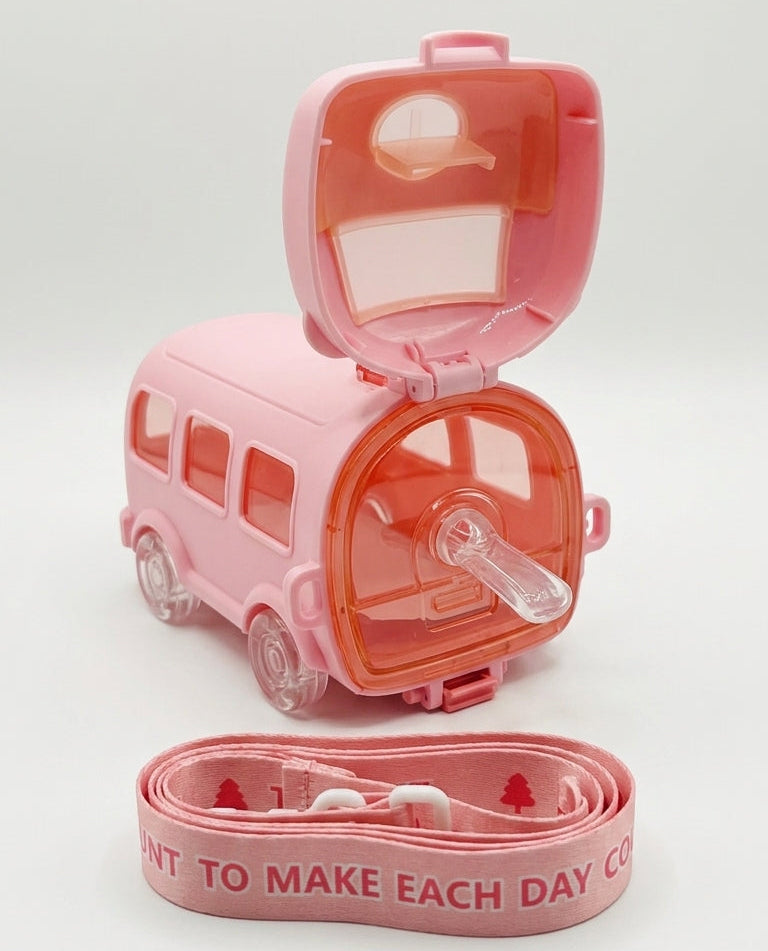 A pink novelty water bottle shaped like a camper van, shown open with its lid and side panel lifted to reveal a clear drinking straw. A matching pink coiled strap with white text lies in front on a clean white background.
